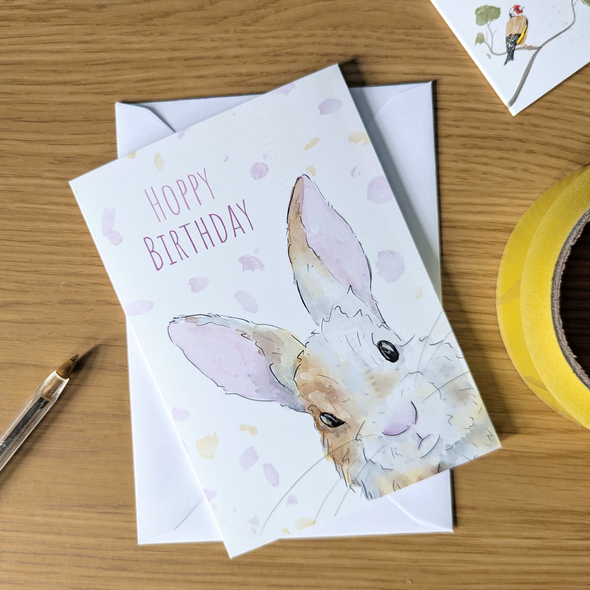 This hoppy birthday bunny card features a cute rabbit hopping from the corner of the card